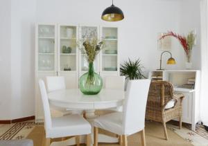 塞维利亚Rodo Arenal的一间用餐室,配有一张带花瓶的白色桌子