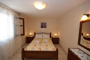 ein Schlafzimmer mit einem Bett und einem Spiegel in der Unterkunft Alexandra Studios 2 in Alonnisos Altstadt