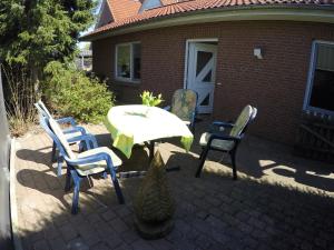 eine Terrasse mit einem Tisch und Stühlen sowie ein Haus in der Unterkunft Ferienapartment Karin in Schneverdingen