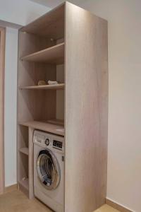 a laundry room with a washing machine in a closet at Milonas House Apartments in Paralia Dionysiou