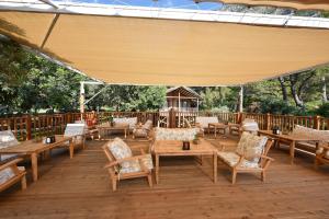 a patio with tables and chairs and a large canopy at Sea Valley Lodge in Faralya