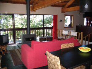 a living room with a red couch and a fireplace at Casa do Castanheiro in Outeiro