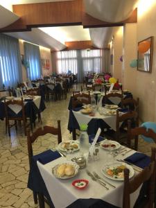 a dining room with tables with plates of food at Hotel Margherita in Sottomarina +20 photos