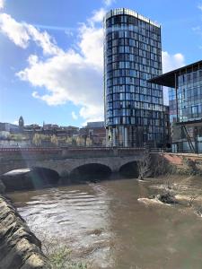 a bridge over a river with a tall building at Snapos Apartments - Blonk Street in Sheffield