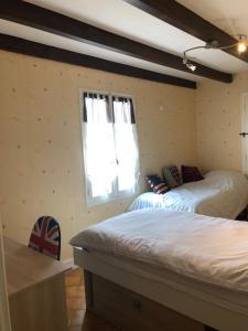 um quarto com 2 camas e uma janela em Chez Lysette em Mesnac