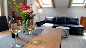 a table with two glasses of wine and a vase of flowers at Hiša Kala in Kobarid