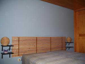 a bedroom with a bed with a large wooden headboard at Casa do Castanheiro in Outeiro