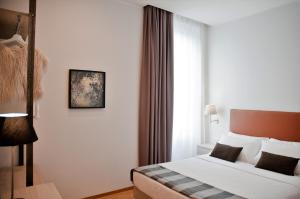 um quarto de hotel com uma cama e uma janela em Giuturna Boutique Hotel em Roma