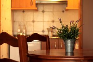 una mesa con un jarrón con flores púrpuras. en Apartamentos El Cruce de Moratón, en Cóbreces