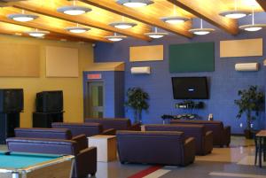 a room with couches and a tv and ping pong tables at Residence & Conference Centre - Sudbury West in Sudbury