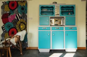 un armario azul con microondas en una habitación en Gîte Chez Dimanche, en Essert