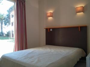 a small bedroom with a bed and a window at Open Residence Golfe Juan in Vallauris