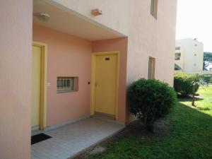 una porta gialla sul lato di un edificio di Open Residence Golfe Juan a Vallauris