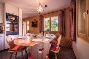 comedor con mesa de madera y sillas en Roossi-Huus 3, en Wengen