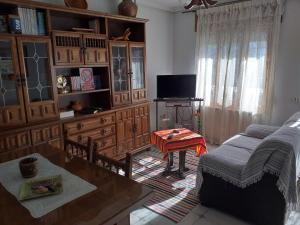 a living room with a couch and a table at Alojamientos AlbaSoraya in La Calzada de Béjar