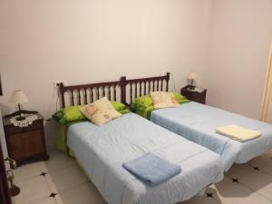 two beds in a room with two tables and two lamps at Alojamientos AlbaSoraya in La Calzada de Béjar