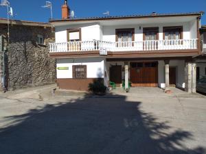 Casa blanca grande con balcón en una calle en Alojamientos AlbaSoraya, en La Calzada de Béjar