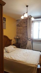 um quarto com uma cama e uma parede de pedra em Casa Nunes em La Coruña