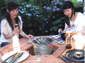 屋久島にあるYakushima Park Guesthouseの二人の女性がテーブルに座って