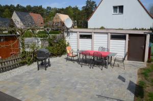 un patio avec une table, des chaises et un grill dans l'établissement FH Hannahliese_WEND, à Karlshagen