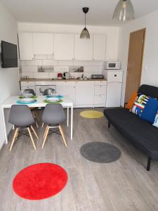 a kitchen and a living room with a table and chairs at Green Garden Plus Apartman in Budapest