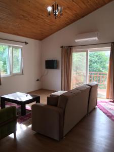 ein Wohnzimmer mit einem Sofa und einem Tisch in der Unterkunft Villa Bilge in Cıralı