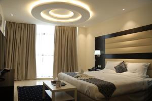 een slaapkamer met een groot bed en een grote kroonluchter bij Lamar Al Bawadi Hotel in Jeddah +193 foto's