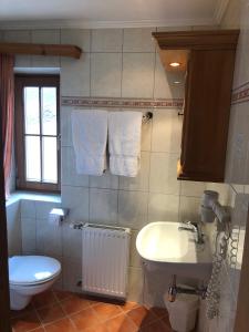 bagno con lavandino, servizi igienici e asciugamani di Landhotel Vordergrub a Kitzbühel
