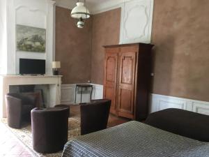 a bedroom with a bed and a cabinet and a fireplace at Chateau de la Bastide in Goudargues