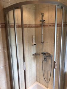 een douche in de badkamer met een wastafel en een douche bij Landhotel Vordergrub in Kitzbühel