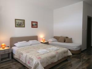 two beds in a room with two lamps on tables at Apartmani Agape in Petrovac na Moru