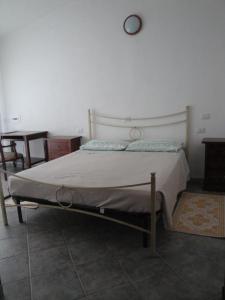 1 cama en un dormitorio con reloj en la pared en La Jatta en Budoni
