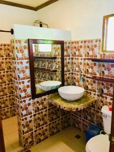 ein Badezimmer mit Waschbecken und Spiegel in der Unterkunft Chekesh Casa in Siquijor