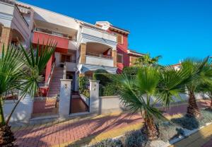 dom z palmami przed nim w obiekcie APARTAMENTO "CARMEN" Zeniamar w mieście Orihuela