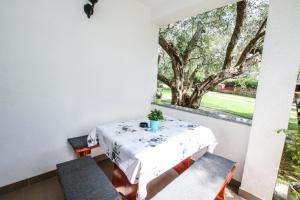 a table and chairs in a balcony with a window at Apartments Vuceric in Peroj