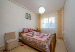 sypialnia z łóżkiem i krzesłem w obiekcie APARTAMENTO "CARMEN" Zeniamar w mieście Orihuela