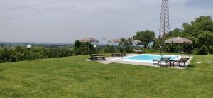 a swimming pool in a grassy field with two tables and chairs at Poggio di Pastrengo in Pastrengo