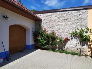 a brick building with a door and red flowers at Apartment Koprivovi in Němčičky +3 photos