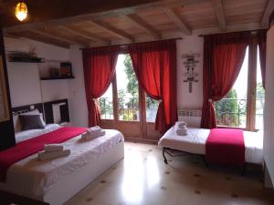 a bedroom with two beds with red curtains and a window at Villa Azur Cap d'Ail in Cap d'Ail