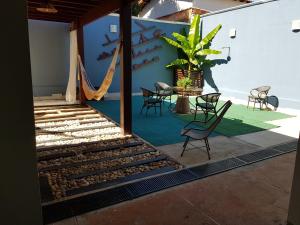 a patio with a hammock and a table and chairs at Casa da Lúcia in Uberlândia