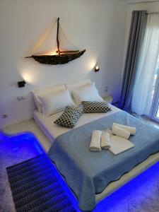 1 dormitorio con 1 cama con un barco en la pared en Enjoy Cyclades studios & suites en Kíthnos
