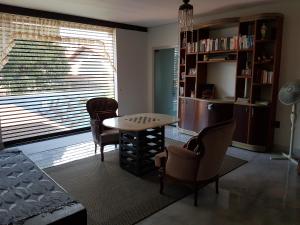 een woonkamer met een tafel en stoelen en een raam bij Casa da Lúcia in Uberlândia