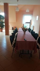una mesa en una habitación con sillas y una mesa con una mesa roja y blanca en Ostoja Jurajska en Hucisko