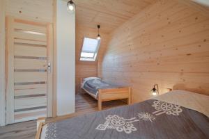 una camera con due letti in una cabina di legno di Domki CHRYCA a Kluszkowce