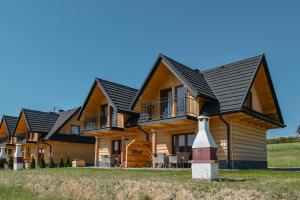 a log home with a black roof at Domki CHRYCA in Kluszkowce