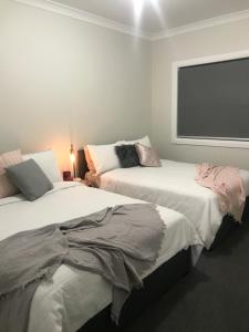 a bedroom with two beds and a large window at Luxury 2br home with King, 5 star private & close in Bathurst