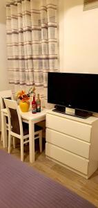 uma sala de estar com televisão e uma mesa com cadeiras em Apartments Sinković em Dubrovnik
