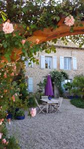 a picnic table and umbrella in front of a building at Chambres d’hôtes du Presbytère in La Bastide-lʼÉvêque