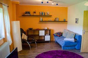 ein Wohnzimmer mit einem blauen Sofa und einem Stuhl in der Unterkunft Ferienwohnung Bad Münder in Bad Münder am Deister
