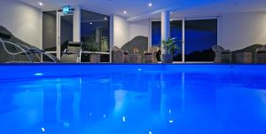 a swimming pool in a hotel with chairs around it at Hotel Creusen in Epen
